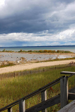 View of beach grass and bay with gray clouds